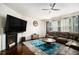 Spacious living room features a fireplace, ceiling fan, and large leather couch at 610 Brickstone Ct, Covington, GA 30016