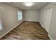 A bright bedroom with neutral colors, two windows and modern flooring at 636 Raven Springs Trl, Stone Mountain, GA 30087