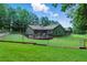 Fenced backyard featuring a deck, lush grass, and a wooded landscape offering privacy at 1920 Daves Creek Trl, Cumming, GA 30041