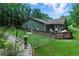 Backyard with wooden deck, lush grass, white rock border and fence at 1920 Daves Creek Trl, Cumming, GA 30041