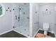 Accessible bathroom featuring a spacious glass shower with grab bars and a comfortable toilet at 1920 Daves Creek Trl, Cumming, GA 30041