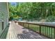 Wooden deck with view of fenced in backyard, lush grass and trees at 1920 Daves Creek Trl, Cumming, GA 30041