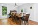 Traditional dining room featuring hardwood floors, a wood table, and natural light from the windows and door at 1920 Daves Creek Trl, Cumming, GA 30041