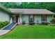 Charming single story home featuring green siding, red shutters and door, and landscaped front yard at 1920 Daves Creek Trl, Cumming, GA 30041