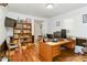 Functional home office featuring a large desk, wood floors, and shelving for storage at 1920 Daves Creek Trl, Cumming, GA 30041