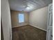 Bedroom with patterned ceiling and one window, featuring neutral walls and carpeted flooring at 2527 Plymouth Way, Conyers, GA 30013
