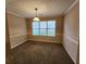 Bright dining room with a pendant light, carpet flooring, and views of the backyard at 2527 Plymouth Way, Conyers, GA 30013