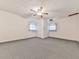 Neutral bedroom with carpeting, a ceiling fan, and a white door between two windows, offering a serene space at 2760 Hembree Ne Rd, Marietta, GA 30062