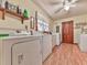 Practical laundry room with a washer, dryer, wood-look flooring, and overhead shelving for organized storage at 2760 Hembree Ne Rd, Marietta, GA 30062