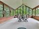 Inviting sunroom with wood paneled walls, large windows offering wooded views, and a round table with seating for four at 2760 Hembree Ne Rd, Marietta, GA 30062