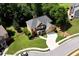 Angled aerial view highlighting a meticulously maintained yard with a two-car garage and front porch at 28 Mcevers Branch Ct, Acworth, GA 30101