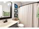 Bathroom with a granite vanity, framed mirror, and shower with patterned shower curtain at 28 Mcevers Branch Ct, Acworth, GA 30101