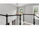 Upstairs hallway featuring a decorative chandelier and plenty of natural light at 28 Mcevers Branch Ct, Acworth, GA 30101