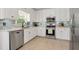 Well-lit kitchen boasts white cabinetry, stainless appliances, and tile backsplash at 28 Mcevers Branch Ct, Acworth, GA 30101