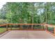 Wooden deck overlooking backyard with lush trees and a partial fence at 3082 Biltmore Woods Dr, Buford, GA 30519