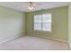 Carpeted bedroom with natural light from a window, a ceiling fan, and neutral paint at 3082 Biltmore Woods Dr, Buford, GA 30519