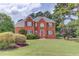 Charming brick two-story home with well-manicured lawn, garden beds, and classic design features at 3082 Biltmore Woods Dr, Buford, GA 30519