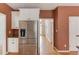 Modern kitchen with stainless steel refrigerator and ample cabinet space with a hallway leading to the foyer at 3082 Biltmore Woods Dr, Buford, GA 30519