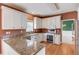 Well-lit kitchen featuring granite counters, wood floors, and white cabinetry at 3082 Biltmore Woods Dr, Buford, GA 30519