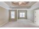 Spacious carpeted main bedroom featuring trey ceiling, ceiling fan, and windows providing ample natural light at 3082 Biltmore Woods Dr, Buford, GA 30519