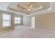 Spacious carpeted main bedroom featuring trey ceiling, ceiling fan, and windows providing ample natural light at 3082 Biltmore Woods Dr, Buford, GA 30519
