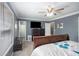 A well-lit bedroom with gray walls, a wooden sleigh bed, and a mounted TV in a modern, comfortable style at 6355 Queens Rd, Douglasville, GA 30135