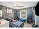 Themed bedroom features unique wood wall, ceiling fan, built in shelving for toys, and Batman-themed bedding at 6355 Queens Rd, Douglasville, GA 30135