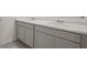 Bathroom vanity with double sinks and gray cabinets with marble countertops at 8593 Secretariat Drive, Lithonia, GA 30058
