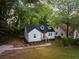 Quaint renovated home with white siding, black trim, and a green lawn at 1956 Washington Rd, Atlanta, GA 30344