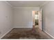 Neutral bedroom featuring neutral walls and carpeting and large open door to another room at 20 Rosebud Ln, Mcdonough, GA 30253
