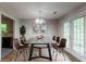 Formal dining room with hardwood floors, a modern table, and an adjacent kitchen area at 20 Rosebud Ln, Mcdonough, GA 30253