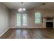 Empty Living room features hardwood floors, a fireplace, and French doors to the outside at 20 Rosebud Ln, Mcdonough, GA 30253