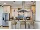 Well-equipped kitchen with stainless steel refrigerator and a breakfast bar with three stools at 2575 Peachtree Ne Rd # 15G, Atlanta, GA 30305