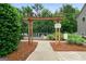 Wooden pergola pathway leading to the community pool with landscaped surroundings at 1629 Marsanne Ter, Kennesaw, GA 30152