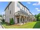 Rear exterior view of a multi-story townhome complex with balconies and green space at 3382 Monarch Ave, Duluth, GA 30096