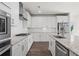 Well-lit kitchen with stainless steel appliances, white cabinetry, and spacious countertops at 3382 Monarch Ave, Duluth, GA 30096