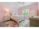 Lovely pink bedroom with a queen bed, floral rug, natural light, and cozy armchair at 3392 Fall Branch Ln, Buford, GA 30519