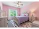 Charming bedroom with pink walls, a queen bed, a patterned rug, and a bright window at 3392 Fall Branch Ln, Buford, GA 30519