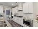 Modern kitchen featuring stainless steel appliances, granite countertops, and stylish white cabinetry at 3392 Fall Branch Ln, Buford, GA 30519