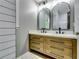 Bathroom with double sink vanity, modern mirrors and a shower with black and white tile surround at 3122 Vandiver Dr, Marietta, GA 30066