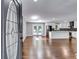 Open-concept living room with wood floors, white walls and trim, and an adjacent modern kitchen at 3122 Vandiver Dr, Marietta, GA 30066