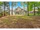 View of the backyard with a two-story home featuring a covered back porch and wooded perimeter at 3473 Whisperwood Nw Ct, Marietta, GA 30064