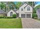 Two-story home with a two-car garage, manicured lawn, and arched windows at 3473 Whisperwood Nw Ct, Marietta, GA 30064