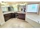 Bright bathroom featuring double vanity, soaking tub, and large mirror, all illuminated by stylish vanity lights at 827 Autry Oak Ct, Johns Creek, GA 30022