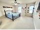 Cozy bedroom with a wrought iron bed frame, fan, natural light, and soft carpeting at 827 Autry Oak Ct, Johns Creek, GA 30022