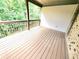 Spacious covered wooden deck with brown railings and brick accents, perfect for outdoor enjoyment at 827 Autry Oak Ct, Johns Creek, GA 30022