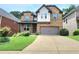 Charming two-story brick home with a well-manicured lawn and a two-car garage at 827 Autry Oak Ct, Johns Creek, GA 30022
