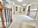 Spacious hallway featuring neutral carpet, staircase with wood and iron railings, and elegant lighting at 827 Autry Oak Ct, Johns Creek, GA 30022