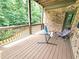 Covered porch with chairs and a relaxing view of surrounding trees at 827 Autry Oak Ct, Johns Creek, GA 30022