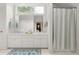 Bathroom featuring double sinks, white cabinets, a large mirror, and a shower with striped curtain at 1824 Mount Paran Nw Rd, Atlanta, GA 30327